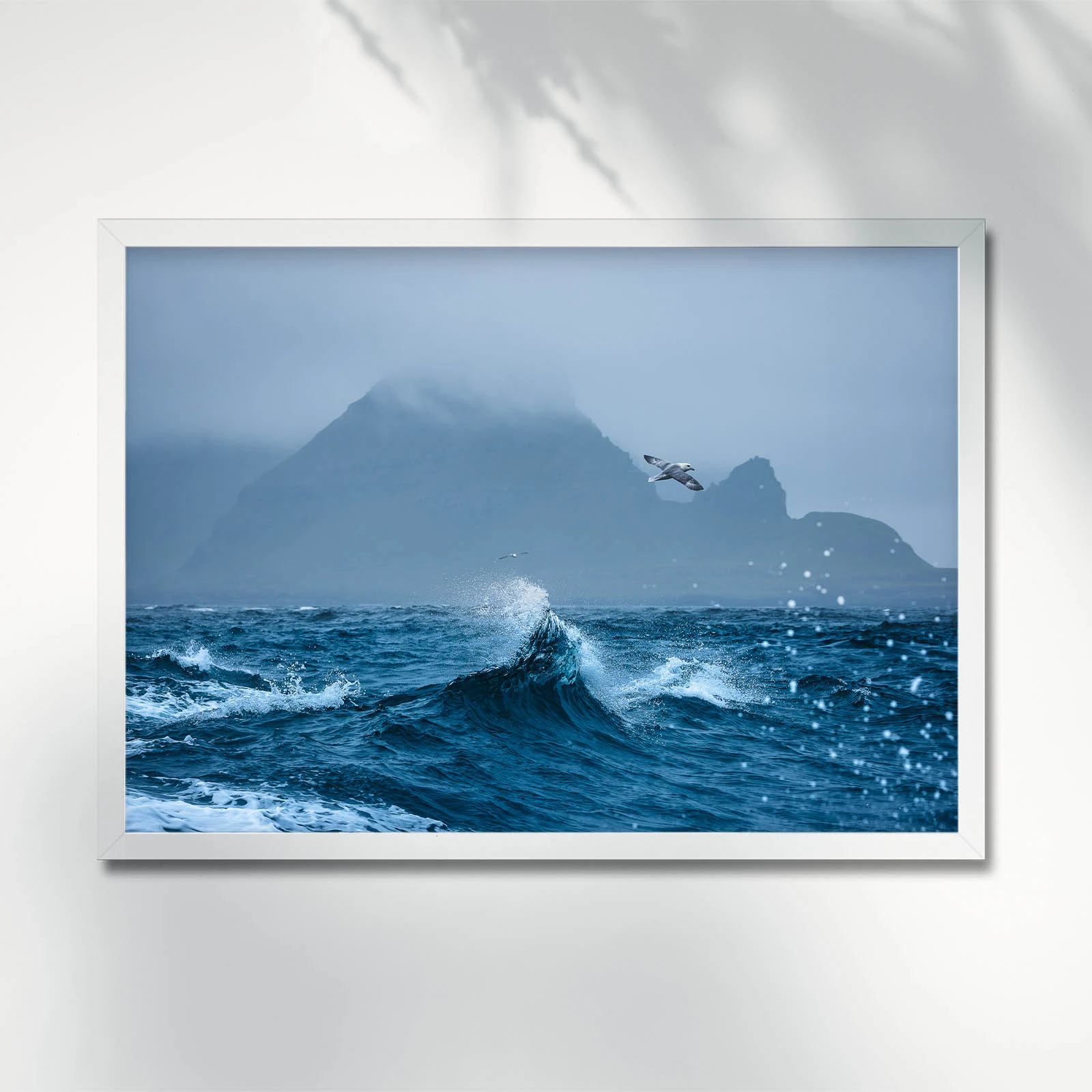 Fulmars flying above crashing waves close to Tindholmur. Faroe Islands